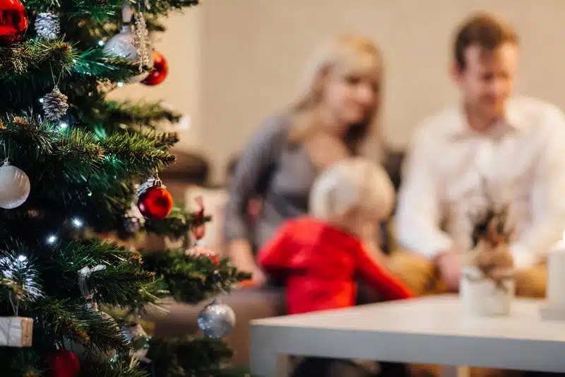 a Christmas tree with a family in the background