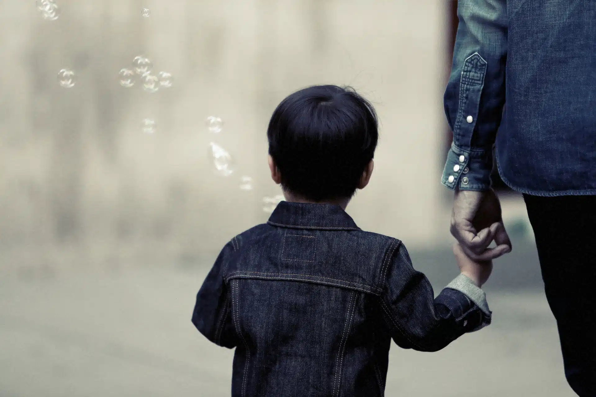 Mother holds her son's hand