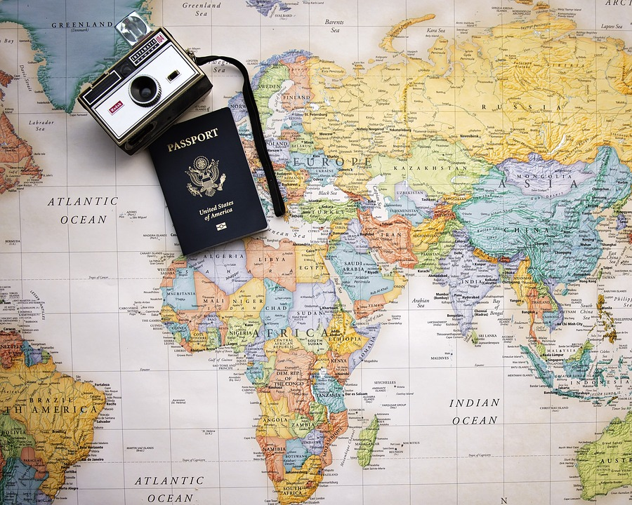 Camera and passport on top of a world map