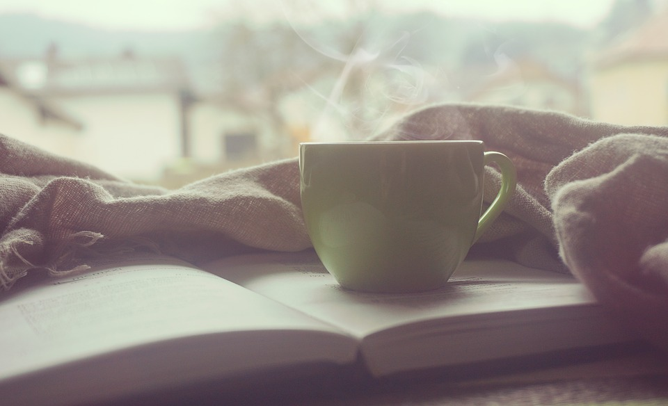 A warm beverage resting on an open book