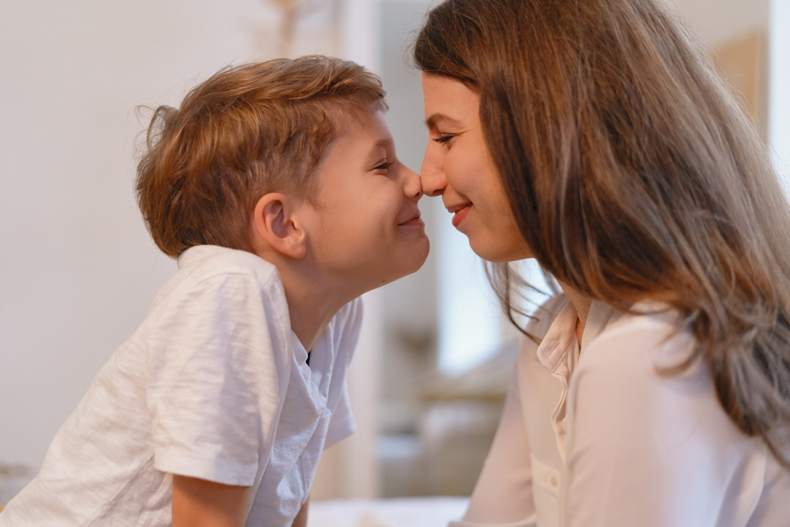 Smiling young mother and her preschool son touching noses.