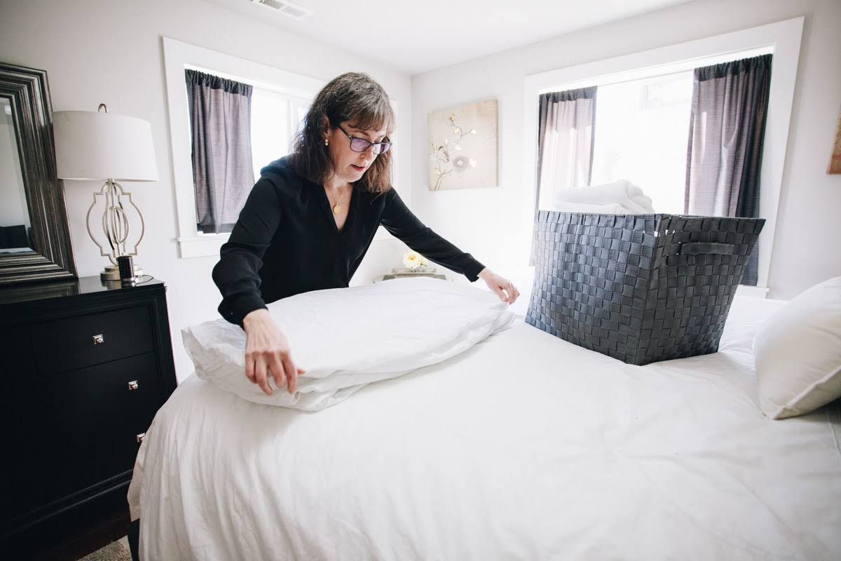 female personal assistant making bed